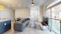 Located at 182 King Ave in Columbus, Ohio's vibrant Short North area, this two-story home offers four bedrooms and five bathrooms across two well-proportioned floors. The main level features an open-concept living and kitchen area bathed in natural light from large windows. The kitchen is equipped with dark espresso cabinetry, granite countertops, stainless steel appliances, and a central island with bar seating beneath a statement pendant light — ideal for cooking and casual dining. The living room flows seamlessly from the kitchen, featuring light wood-look flooring, recessed lighting, and a ceiling-mounted light fixture. Multiple windows provide views of the surrounding neighborhood. The bedrooms are carpeted and designed for comfort, each with natural light from windows and ample space for sleeping and studying. Select bedrooms include built-in closets. The five bathrooms are consistently finished with large-format tile flooring, granite-topped dark wood vanities, and tiled walk-in showers with brushed nickel fixtures — offering a clean, modern aesthetic throughout. A staircase connects the two floors, with space distributed evenly between levels. This home combines modern finishes with functional design.
