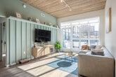 Located at 301 N Broom St in Madison, WI, this single-floor 5-bedroom, 2-bathroom unit showcases a modern design anchored by a distinctive wood-plank ceiling that runs throughout the main living areas, adding warmth and architectural character. The open-concept kitchen and living room form the heart of the space, where light-toned cabinetry, stainless steel appliances, a subway tile backsplash, and a peninsula with bar seating create a functional yet stylish setting. Pendant lighting and track fixtures complement the natural light that pours in through large floor-to-ceiling windows. The living room opens directly onto a private balcony, offering views of the surrounding Madison cityscape. In-unit stacked washer and dryer add everyday convenience. Each of the five bedrooms features sliding barn-style doors, built-in shelving, and hardwood-style flooring, with several rooms benefiting from elevated ceilings that enhance the sense of space. The primary bedroom is comfortably sized with clean, minimalist finishes. Both bathrooms are outfitted with glass-enclosed walk-in showers, rain showerheads, handheld fixtures, built-in shelving, and modern vanities with ample counter space, delivering a refined, hotel-like experience throughout.