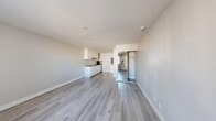 Located at 629 S Main St, Unit 206, in downtown Las Vegas, this studio unit offers a thoughtfully designed open-plan layout that combines the living and kitchen areas into a single, efficient space. Light gray laminate wood flooring runs throughout, lending a clean, contemporary feel and visually expanding the room.

The kitchen is neatly integrated along one wall, featuring white shaker-style cabinetry — both upper and lower — paired with granite-patterned countertops, a stainless steel single-basin sink, a built-in cooktop, and a ventilation hood. The cabinetry provides ample storage without encroaching on the open feel of the living area.

The living space is bright and airy, benefiting from a window fitted with vertical blinds that allows natural light to filter in. A wall-mounted HVAC unit ensures year-round climate comfort. Neutral beige walls and white trim maintain a clean, cohesive aesthetic throughout.

A mirrored sliding-door closet offers convenient storage and reflects light to enhance the sense of openness. A separate bathroom with a vanity and sink is accessible from the main living area. Recessed lighting and smoke detectors are installed in the ceiling, completing a practical and move-in-ready unit suited for downtown Las Vegas living.