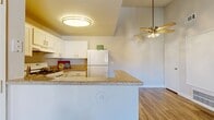 Located in Murrieta, California, this 2-bedroom, 1-bathroom single-story residence offers a practical and well-appointed layout. The combined kitchen and living room serves as the heart of the home, where a peninsula with granite-style countertops visually separates the two spaces. The kitchen is equipped with white cabinetry, a gas range, a full-size refrigerator, and a sink with a window view, all set atop wood-style flooring that runs throughout the main living areas. A ceiling fan with a light fixture keeps the living space comfortable, while a sliding glass door floods the room with natural light and provides direct access to an outdoor patio area.

Both bedrooms are carpeted and feature mirrored sliding closet doors that enhance the sense of space. The primary bedroom is generously sized with tall ceilings and connects to the hallway, while the second bedroom benefits from natural light through a large window. The shared full bathroom is clean and functional, featuring a white vanity with a granite-style countertop, a large mirror, and wood-style flooring. A hallway connects all rooms, contributing to an efficient and cohesive floor plan throughout this well-maintained residence.