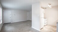 Located at 222 Merrimac Trail in Williamsburg, Virginia, this single-floor residence offers a practical and comfortable layout throughout. The open living area features neutral-toned carpet and connects seamlessly to a kitchen equipped with white cabinetry, stone-look countertops, and tile flooring, creating a functional flow between spaces. The entry area provides direct access to additional rooms, with clean white doors and light-toned walls lending a bright, airy feel throughout. The bedrooms are carpeted and outfitted with ceiling fans featuring integrated lighting, providing comfort year-round. One bedroom notably includes dual reach-in closets, offering generous storage capacity, while another benefits from a window that invites natural light and views of surrounding greenery. The bathroom is finished with classic white subway tile surrounding a soaking tub and shower combination, complemented by tile flooring and chrome fixtures, creating a clean and timeless aesthetic. Throughout the residence, neutral wall tones and consistent flooring choices contribute to a cohesive and understated interior atmosphere, making the space well-suited for easy personalization.