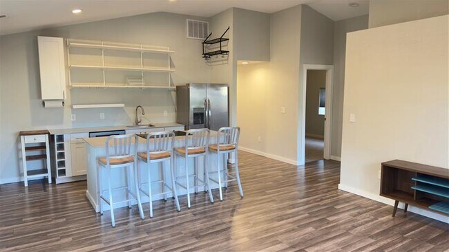 Vista de la cocina desde la sala de estar. Se puede ver el dormitorio de invitados y el pasillo que lleva al baño. - 521 Perry St