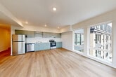 Located at 401 Union Ave SE in Olympia, Washington, this thoughtfully designed one-bedroom, one-bathroom unit offers a clean, modern aesthetic throughout its single-floor layout. Light wood-tone luxury vinyl plank flooring runs seamlessly across every room, creating a cohesive and bright atmosphere.

The open-concept kitchen and living area serves as the heart of the unit. The kitchen is outfitted with sage-green cabinetry, white countertops, open upper shelving, and a full suite of stainless steel appliances including a refrigerator, electric range, and dishwasher. Recessed lighting illuminates the space, while large windows allow abundant natural light and provide views of the surrounding Olympia streetscape and greenery.

The bedroom is a well-proportioned, quiet retreat featuring a sliding closet, white walls, and its own window for natural light. A second closet is also available within the unit, offering practical storage solutions.

The bathroom mirrors the home's modern palette with sage-green cabinetry, a white countertop vanity, a framed mirror, and clean white walls. A hallway connects all areas of the unit, featuring a dedicated electrical panel and additional closet access. The overall design is contemporary, functional, and move-in ready.