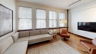 Located at 1519 Main St in the heart of downtown Dallas, this urban loft-style unit blends historic character with modern finishes throughout its single-floor layout. Rich hardwood floors and soaring ceilings with exposed ductwork and industrial-style track lighting set a distinctive tone from the moment you enter through the striking solid wood entry door.

The open-concept kitchen is outfitted with dark espresso cabinetry, white subway tile backsplash, white quartz countertops, and a full suite of stainless steel appliances including a refrigerator, electric range, over-the-range microwave, and dishwasher. A dark kitchen island provides additional prep and dining space.

The living area is bathed in natural light from a bank of large windows that frame views of the surrounding downtown streetscape, with warm hardwood floors and ample room for generous seating arrangements. The bedroom is equally well-lit, featuring multiple windows, a ceiling fan, and enough space to comfortably accommodate a full bedroom suite.

The bathroom includes a combination tub and shower, a clean white vanity with undermount sink, and hardwood flooring that carries through from the main living areas. Throughout the space, warm wood tones, neutral walls, and contemporary fixtures come together to create a functional and stylish urban retreat.