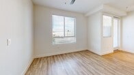 Located at 418 N Main St in Corona, CA, this well-appointed 1-bedroom, 1-bathroom unit offers a thoughtfully designed layout across a single floor. The open-concept kitchen is a standout feature, showcasing white shaker cabinetry, a subway tile backsplash, dark quartz countertops, a peninsula island with pendant lighting, and a full suite of stainless steel appliances including a gas range, microwave, dishwasher, and refrigerator. Light wood-tone flooring flows through the main living areas, complementing the bright, neutral palette throughout. The combined dining and living area provides a comfortable, functional space with natural light from nearby windows. The bedroom features plush carpeting, a ceiling fan, a large window with outdoor views, and access to a generously sized walk-in closet with built-in shelving. The bathroom is finished with a white vanity, granite-style countertop, a soaking tub, and matching wood-tone flooring. A dedicated in-unit laundry room accommodates a full-size washer and dryer with overhead cabinetry for additional storage. The unit also includes a private balcony and a second closet, rounding out a practical and comfortable living space.