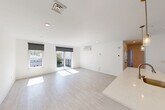 Located at 42 N Beacon Street in Boston's Allston neighborhood, this modern unit offers four bedrooms and two bathrooms across a thoughtfully designed single-floor layout. The open-concept living area is bright and airy, featuring light hardwood-style flooring, recessed lighting, and large windows with roller shades that invite abundant natural light. Sliding glass doors lead to a private balcony, extending the living space outdoors with views of the surrounding neighborhood.

The kitchen is a standout feature, showcasing a generous waterfall-edge island with an integrated sink, sleek white cabinetry, a white subway tile backsplash, stainless steel appliances, and elegant pendant lighting — ideal for both cooking and entertaining.

Each bedroom is well-proportioned and finished with the same light flooring and clean white walls. Individual wall-mounted mini-split units provide climate control in the bedrooms and living areas. The primary bedroom enjoys direct balcony access through sliding glass doors. Several bedrooms offer cityscape views through large windows.

The bathrooms are cleanly appointed with tiled showers, warm wood vanities, and mirrored medicine cabinets. A dedicated laundry area and four closets add practical convenience. The unit also includes a welcoming entrance and hallway, completing a well-organized and modern living space.