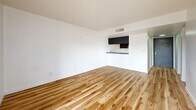 Located at 1515 W Missouri Ave in Phoenix, AZ, this 2-bedroom, 4-bathroom unit offers a clean, modern aesthetic across a single floor. Light-toned hardwood flooring runs throughout the space, creating a warm and cohesive look that ties every room together. Crisp white walls and textured ceilings complement the natural warmth of the floors, while bold black-framed six-panel doors serve as a striking design contrast throughout.

The open living area features a pass-through kitchen with dark cabinetry and a countertop bar, providing a functional yet stylish layout. Natural light filters into the bedrooms through windows dressed with vertical blinds, enhancing the bright, airy feel of each room. The primary bedroom offers a comfortable footprint with access to closet space, while the second bedroom is equally well-proportioned.

The four bathrooms are finished in clean white with light wood flooring carried in from the main areas. Bathroom configurations include both shower-tub combos and walk-in shower stalls, framed by dark trim that echoes the design language found throughout the unit. A dedicated closet and connecting hallway round out the functional layout, making this a well-organized and thoughtfully designed Phoenix residence.