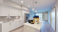 Located at Mayla in Pompano Beach, Florida, this 2-bedroom, 2-bathroom residence offers a thoughtfully designed single-level layout with contemporary finishes throughout. The open-concept kitchen is a standout feature, outfitted with crisp white shaker cabinetry, quartz countertops, a subway tile backsplash, and a full suite of stainless steel appliances including a refrigerator with ice maker, range, microwave, and dishwasher. A central island with pendant lighting adds both function and style, flowing seamlessly into the living area, which is bathed in natural light from large sliding glass doors that open to a private balcony with outdoor views. Wood-look tile flooring extends throughout the living spaces, lending a warm yet modern aesthetic. Both bedrooms are generously proportioned, with large windows framing pleasant views of the surrounding area. The primary suite includes a spacious walk-in closet with built-in shelving and hanging rods. The bathrooms are elegantly appointed with large-format tile surrounds, soaking tubs, white vanities, and backlit mirrors. The secondary bedroom also benefits from direct balcony access. Clean neutral tones and modern fixtures create a bright, airy ambiance throughout this well-appointed Pompano Beach residence.