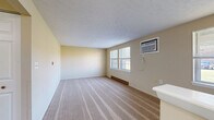 Located at 45 East St in Victor, NY, this single-floor, one-bedroom, one-bathroom residence offers a functional and comfortable layout. The combined kitchen and living area serves as the heart of the home, featuring warm rich-toned wood cabinetry, white appliances including a full-size refrigerator and electric range, and durable light gray laminate flooring. A dedicated closet near the kitchen entry provides convenient storage. Natural light filters in through multiple windows, enhancing the bright, neutral color palette throughout.

The spacious bedroom is finished with plush wall-to-wall carpeting and neutral warm-toned walls, creating a calm and restful environment. A window allows natural light to fill the room, and a baseboard heating system ensures year-round comfort. The room also offers a dedicated closet for added storage.

The bathroom is clean and practical, featuring a full tub/shower combination with safety grab bars, making it both functional and accessible. Textured ceilings are present throughout the home, adding a classic touch to the overall aesthetic. The layout is efficient and well-organized, making excellent use of the available space. This residence is well-suited for those seeking a straightforward, comfortable home in the Victor, NY area.