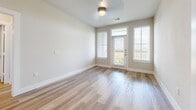 Located in Leander, TX, this well-appointed 2-bedroom, 2-bathroom residence offers a thoughtfully designed single-level floor plan with a clean, modern aesthetic throughout. The open-concept kitchen and living area serves as the heart of the home, featuring light wood-style flooring, crisp white cabinetry extending to the ceiling, dark granite countertops, a subway tile backsplash, and stainless steel appliances including a gas range and French door refrigerator. The living area is bathed in natural light from large windows and a glass door that opens to a private balcony with sweeping, unobstructed views of the Texas Hill Country — a true standout feature of this residence. Both bedrooms are carpeted and equipped with ceiling fans and windows framing lush greenery outside. The primary bedroom includes a generously sized walk-in closet with dual clothing rods and built-in shelving. The primary bathroom showcases a dark granite dual vanity with white cabinetry, wood-style flooring, and a tiled shower-tub combination. Neutral tones, clean lines, and consistent finishes create a cohesive and inviting ambiance throughout the entire space.