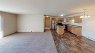 This single-floor, 2-bedroom, 2-bathroom residence is thoughtfully laid out to maximize functionality and comfort. The open-concept living and dining area flows seamlessly from the kitchen, featuring plush carpeting and a wall-mounted air conditioning unit. A chandelier adds a touch of elegance to the dining space, while baseboard heating ensures year-round comfort throughout the unit.

The kitchen is well-appointed with warm oak cabinetry, dark laminate countertops, a central island with additional counter space, and durable tile flooring. Appliances include a black electric range, stainless steel microwave, dishwasher, and a full-size refrigerator. A double stainless steel sink completes the practical workspace.

Both bedrooms are generously sized with soft carpet flooring, natural light from windows fitted with horizontal blinds, and baseboard heating. One bedroom includes a walk-in closet accessible through a classic six-panel oak door.

The two bathrooms feature tile flooring and dark laminate vanity countertops with vessel sinks and large mirrors. One bathroom includes a full tub/shower combination, while the other offers a more compact layout. Both are clean and functional, rounding out this well-designed residential space.