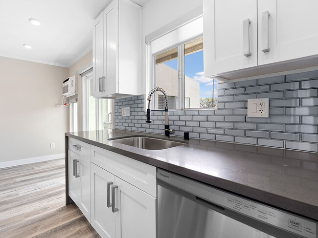 Blue tiled kitchen with stainless steel oven, fridge, dish washer, and fixtures. - 1249 South Bundy