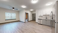 Located at 2024 US-70 W in Dickson, Tennessee, this well-appointed 2-bedroom, 2-bathroom residence offers a thoughtfully designed single-floor layout. The open-concept kitchen and living area serves as the heart of the home, featuring light hardwood-style flooring, flush ceiling lighting, and a clean, contemporary aesthetic. The kitchen is equipped with stainless steel appliances—including a refrigerator, range, microwave, and dishwasher—complemented by granite countertops, a double-basin sink with a matte black faucet, white upper shaker cabinets, gray lower cabinets, and a subtle tile backsplash. Both bathrooms mirror the modern design with granite-topped vanities, gray cabinetry with black hardware, tub-shower combinations, and wood-style flooring. The bedrooms offer plush carpeting, and the primary bedroom includes a distinctive warm-toned accent wall, a ceiling fan, and multiple windows that invite natural light and outdoor views. The second bedroom also features large windows with blinds. Four closets provide generous storage throughout. The overall palette—neutral walls, gray accents, and black hardware—creates a cohesive, move-in-ready environment.