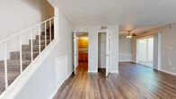 Located at 2590 Capitales Dr in Rancho Cordova, CA, this two-story, 3-bedroom, 2-bathroom home offers a practical and well-organized layout across two floors. The main level features a bright living room with wood-look flooring, a ceiling fan, and a large window fitted with vertical blinds that allows ample natural light. An entry closet and staircase are conveniently positioned near the front door. The kitchen is efficiently designed with warm honey-toned cabinetry, granite-style countertops, a double sink, and white appliances including a refrigerator, electric range, and built-in microwave. A full bathroom on this level includes a wood-vanity with stone-style countertop and a tub-shower combo with wood-look flooring. Upstairs, three carpeted bedrooms offer comfortable living spaces, each with vertical-blind windows — some with views of surrounding greenery. The primary bedroom provides a generous footprint with direct hallway access. A second full bathroom serves the upper level. Throughout, textured ceilings, neutral wall tones, and clean white trim create a consistent, understated aesthetic. A dedicated closet and hallways on both floors add to the home's functional storage and circulation.
