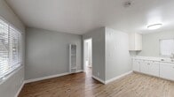 Located at 414 South 4th Street in San Jose, California, this single-floor apartment offers a well-organized and efficient layout. The interior is finished with a consistent neutral gray palette and clean white trim throughout, creating a calm and cohesive atmosphere.

The living room features warm wood-look flooring and soft gray walls, with a wall-mounted heater unit providing a practical heating solution. An open sightline connects the living area to the kitchen, enhancing the sense of space. The kitchen is equipped with white shaker-style cabinetry, a double-basin sink, a white range, and a refrigerator, all complemented by light wood-look flooring and a window with blinds that brings in natural light.

A separate room with plush carpeted flooring, soft gray walls, and a large window with horizontal blinds provides views of the surrounding neighborhood and allows for generous natural light. The bathroom features a clean, all-white tile surround with a combination tub and shower, a handheld showerhead, and a window for ventilation.

Circulation is facilitated by multiple hallways and four closets, offering notable storage capacity relative to the overall footprint. The unit's straightforward, functional design makes efficient use of every square foot.