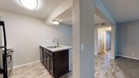 Located at 2323 North Woodlawn Boulevard in Wichita, Kansas, this single-floor residence offers a well-appointed layout with a blend of updated finishes and classic architectural details. The open-concept living area is a standout feature, anchored by a striking floor-to-ceiling brick fireplace with a raised hearth that adds warmth and character to the space. Plank-style flooring flows through the main living and kitchen areas, complemented by neutral-toned carpet in the bedrooms and living room. A ceiling fan overhead enhances comfort throughout the main living space.

The kitchen is thoughtfully designed with dark espresso cabinetry, light granite-style countertops, black appliances including a range and overhead microwave, and a peninsula with a sink that opens to the living area — ideal for everyday convenience. Textured ceilings are present throughout the home, adding a classic touch.

The bedrooms are generously sized, each featuring plush carpet flooring, neutral paint tones, and windows with blinds that allow natural light to filter in. The bathrooms are equipped with matching dark cabinetry, granite-style vanity tops, and chrome fixtures. One bathroom features a walk-in shower stall, while another includes a toilet, vanity, and grab bar for added accessibility. A hallway connects the private spaces, completing this functional and updated single-floor layout.