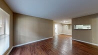 Located at 2801 Walnut Bend Lane in Houston, TX, this single-floor residence offers a practical and comfortable layout with two bedrooms and two full bathrooms. The open living area features rich, dark hardwood-style flooring and neutral warm-toned walls, creating a clean and inviting atmosphere. A front entry door with an adjacent window allows natural light to brighten the main living space. The galley-style kitchen is efficiently designed with white cabinetry, a tile backsplash, granite-style countertops, a double sink, and black appliances including a range and refrigerator, all set on wood-style flooring. Both bathrooms are finished with matching granite-style vanity countertops, wood-style flooring, white subway-tiled tub-shower combinations, and classic fixtures. The two bedrooms are carpeted for comfort and each includes a ceiling fan with light fixture and a closet. The primary bedroom offers a generous footprint, while the secondary bedroom features a window with outdoor views. Hallways connect the rooms efficiently throughout the unit, and two dedicated closets provide ample storage. The overall design is consistent and functional, with a neutral palette that offers a versatile canvas throughout the home.
