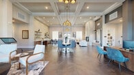 This thoughtfully designed single-floor amenity center offers a comprehensive suite of spaces across 14 rooms, totaling a generous footprint that caters to both social and professional needs. The centerpiece is a grand open-concept clubroom distinguished by soaring coffered ceilings, large-format tile flooring laid in an elegant herringbone pattern, and a dramatic cluster of gold pendant chandeliers. A floor-to-ceiling fireplace anchors the living area, while a built-in wet bar and open shelving define a casual lounge zone. Multiple seating arrangements and abundant natural light from large windows create a welcoming, upscale atmosphere throughout.

The fitness center is well-equipped with cardio machines, strength training equipment, free weights, and stability balls, all set beneath a tray ceiling with ceiling fans and full-wall mirrors. Large windows flood the space with natural light and outdoor views.

The business center includes two dedicated conference rooms outfitted with long tables, ergonomic seating, wall-mounted displays, and modern gold-toned light fixtures. Private individual workstations with built-in desks and natural window light provide quiet spaces for focused work. Carpeted corridors with frosted glass-panel doors connect these functional zones seamlessly.

The leasing office features rich wood-toned desks, high ceilings, and curated artwork, presenting a polished and professional environment throughout.