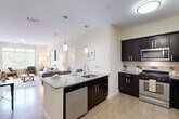 Located at 2100 Summit Dr in Bridgewater, MA, this thoughtfully designed 2-bedroom, 2-bathroom residence offers a comfortable and functional single-floor layout. The open-concept kitchen is a standout feature, showcasing dark espresso cabinetry, granite countertops, stainless steel appliances — including a gas range, built-in microwave, dishwasher, and refrigerator — and a central island with pendant lighting. Light wood-style flooring flows throughout the main living areas, complementing the neutral color palette. The living room is bright and welcoming, anchored by large windows that invite ample natural light and provide views of the surrounding greenery. The spacious primary bedroom features plush carpeting and direct access to a dedicated walk-in closet. The en-suite primary bathroom includes a double granite vanity, dark cabinetry, and tiled flooring. The second bedroom is equally well-sized, also with carpeted floors and its own walk-in closet. A second full bathroom with a tub/shower combination and granite vanity serves this bedroom. Additional conveniences include a dedicated laundry area, utility room, and ample closet storage throughout, making this a highly practical and polished residence.