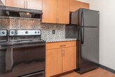 Located in Lapeer, Michigan, this single-floor residence offers a thoughtfully organized layout that balances functionality and comfort throughout its well-defined spaces.

The galley-style kitchen is a standout feature, outfitted with warm wood cabinetry, granite-look countertops, a tile backsplash, and black appliances including a range, refrigerator, and dishwasher. Hardwood-style flooring runs the length of the kitchen, adding warmth and durability underfoot.

The living area is open and inviting, with the same hardwood-style flooring continuing from the kitchen. A ceiling fan provides airflow, while a sliding glass door floods the space with natural light and offers outdoor views. A pass-through counter connects the living area to the kitchen, enhancing the open feel of the layout.

The bedrooms are carpeted for comfort and feature generous closet space, with one bedroom offering dual bifold closet doors. Baseboard heating and window blinds are present throughout, ensuring year-round comfort and privacy. Natural light enters through multiple windows, providing views of the surrounding greenery.

The bathroom is clean and functional, featuring tile flooring, a granite-top vanity with wood cabinetry, a full tub-shower combination, and baseboard heating. Overall, this residence presents a practical and comfortable living environment in a convenient Lapeer location.