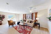 Located at West Creek Village Drive in Elkton, Maryland, this single-floor, 2-bedroom, 2-bathroom home offers a thoughtfully designed layout that maximizes comfort and functionality. The combined living and dining area forms the heart of the home, with the spacious living room featuring soft wall-to-wall carpeting, a ceiling fan with light fixture, and multiple windows dressed with warm curtains that fill the space with natural light. Sliding glass doors provide direct access to the outdoors. The dedicated dining area is finished with tile flooring and offers its own window, creating a bright and pleasant setting for meals. A central hallway connects the main living spaces to the private quarters, lined with neutral warm-toned walls and ceiling lighting. The primary bedroom is generously proportioned, with plush carpet and a closet, while the second bedroom offers similar comfort. Both bathrooms are clean and functional, each featuring a vanity with storage, tile flooring, and well-lit mirrors. The home also includes a dedicated laundry room and four closets, providing ample storage. With a neutral color palette, carpeted bedrooms, and an efficient single-level floor plan, this home delivers a practical and comfortable living environment.