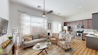 Located in Mesa, AZ, this single-story, 2-bedroom, 2-bathroom residence offers a thoughtfully designed open-concept layout that maximizes every square foot. The combined living room and kitchen area serves as the heart of the home, featuring soaring ceilings, a sleek ceiling fan, and large windows dressed with sheer curtains that flood the space with abundant natural light. Wood-look flooring runs seamlessly throughout, lending warmth and visual continuity to every room.

The kitchen is well-equipped with rich dark cabinetry extending to the ceiling, a mosaic tile backsplash, stainless steel appliances, and light countertops. A dining area sits adjacent, offering a natural flow for entertaining. The living area provides generous room for seating and includes a wall-mounted TV setup.

The primary bedroom is a comfortable retreat, featuring a ceiling fan, dual windows, a high transom window for added light, and direct access to a private en-suite bathroom. The en-suite includes a dual-sink vanity with dark cabinetry, light countertops, and a glass-enclosed walk-in shower, with a walk-in closet featuring built-in shelving and ample hanging space nearby. The second bedroom is versatile and also includes a ceiling fan and access to a closet. Both hallways connect the rooms efficiently, completing this cohesive and functional floor plan.