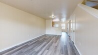Located at 5555 Tinley Park in Columbus, Ohio, this two-story home offers a practical and well-organized layout across two floors. The main level features a spacious, open living area with grey wood-look hard surface flooring and neutral warm-toned walls that create a clean, bright atmosphere. The kitchen is equipped with warm oak cabinetry, white appliances including a range and refrigerator, and ample counter space, seamlessly connected to the living area via a pass-through window. A hallway with closet storage and a bathroom round out the first floor. Upstairs, two bedrooms provide comfortable accommodations, including a generously sized primary bedroom carpeted in neutral grey tones. The bedrooms feature large windows that invite natural light and include built-in closets with hanging rods for convenient storage. Three bathrooms throughout the home include full bath configurations with tub-shower combos, wood-toned vanities, and clean white fixtures. A dedicated staircase connects the two floors. The consistent use of soft, neutral tones and durable flooring materials throughout gives the home a cohesive and move-in-ready feel.