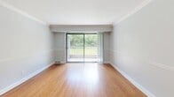 This 2-bedroom, 1-bathroom apartment in Ypsilanti, MI offers a well-organized single-floor layout with consistent, modern finishes throughout. The living room is highlighted by warm hardwood flooring, crown molding, soft gray walls with chair rail detailing, and a sliding glass door that opens to a private balcony overlooking lush greenery — filling the space with natural light and outdoor views. The galley-style kitchen features white shaker cabinetry, granite countertops, stainless steel appliances including a refrigerator and dishwasher, and large-format tile flooring, offering a clean and functional cooking space. The spacious primary bedroom includes hardwood floors, a large sliding closet, crown molding, and a window with garden views. The second bedroom is equally well-appointed with hardwood floors, natural light, and the same refined trim work. The full bathroom is finished with dark tile flooring, a white vanity with storage, and a tub-shower combination. Consistent crown molding, chair rail accents, and a neutral gray-and-white palette create a cohesive, polished ambiance throughout the entire apartment.