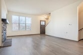 Located at 1004 Cherry Blossom Dr in Madison, WI, this multi-level home spans three floors and offers a well-organized layout with 2 bedrooms, 3 bathrooms, and a range of practical amenities. The entry level includes an attached garage with an automatic opener, providing convenient and secure parking. The main living floor features an open-concept design with light hardwood-style flooring throughout. The living room is anchored by a striking stacked-stone fireplace with a rich wood mantel, creating a warm and inviting focal point. The kitchen is well-appointed with warm-toned cabinetry, granite countertops, a peninsula with pendant lighting, and black appliances. A sliding glass door leads to a private balcony, bringing in natural light and outdoor views. A staircase with a wood railing connects all three levels. The upper floor houses both bedrooms, each featuring plush carpeting, ceiling fans, and natural light from windows with blinds. The spacious primary bedroom includes direct access to an en suite bathroom. Two additional bathrooms serve the home, each featuring clean, bright finishes. A dedicated laundry room with a full-size washer and dryer adds everyday convenience. Three closets provide ample storage throughout.