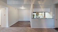 Located at 10010 Whitehurst Dr in Dallas, Texas, this single-story home offers a well-organized layout with a variety of functional living spaces. The living room serves as the heart of the home, featuring a dramatic vaulted ceiling with a ceiling fan, plush carpeted flooring, a fireplace, and windows on multiple sides that invite an abundance of natural light. A patio door provides convenient access to the outdoors.

The kitchen is positioned adjacent to the living area and connected via a pass-through counter, creating an open and social feel. It features dark wood cabinetry, a speckled granite-style countertop, a tile backsplash with a neutral linear pattern, a white electric range, and wood-look vinyl flooring that extends into the dining area.

The bedrooms are carpeted and well-lit, each equipped with ceiling fans and windows fitted with blinds. One bedroom includes a walk-in closet, offering practical storage. The textured ceilings are consistent throughout the home, contributing to a classic residential character.

The bathroom includes a wide granite-style countertop, an extended vanity mirror, and clean neutral walls, providing a functional and tidy space. Throughout the home, the neutral color palette and consistent finishes create a cohesive and welcoming atmosphere suited for comfortable everyday living.