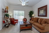 This single-floor residence is thoughtfully designed with an open-concept layout that seamlessly connects the living, dining, and kitchen areas. The living room features crown molding, a ceiling fan, soft carpeting, and a sliding glass door that invites natural light and outdoor views. A half-wall partition separates the kitchen from the main living space, providing both visual openness and functional definition.

The kitchen is well-equipped with white cabinetry, dark granite-style countertops, a double-basin sink, and white appliances including a stove and built-in microwave. Wood-look flooring adds warmth and durability underfoot. A pass-through window connects the kitchen to the dining area, where a glass-top dining table sits beneath a pendant light.

Two bedrooms offer comfortable retreats, each with carpeted floors, natural light from windows, and ample closet space. The primary bedroom includes a walk-in closet and direct access to an en-suite bathroom. Both bathrooms feature sliding glass-enclosed tub-shower combinations, wood-look flooring, and neutral wall tones, creating a clean and functional aesthetic throughout.