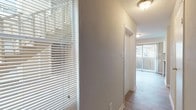 Located at Treeside Park, this single-floor residence offers a well-organized layout designed for comfortable everyday living. The interior showcases a mix of rich wood-style flooring in the main living areas and hallways, providing a warm and cohesive aesthetic throughout. A galley-style kitchen features white cabinetry, granite-look countertops, a stainless steel sink, and black appliances including a range, refrigerator, and dishwasher, all complemented by light wood-style flooring and a window that brings in natural light. The hallway connects the living spaces efficiently, with windows fitted with horizontal blinds that allow for adjustable light control and views to the outdoors. The bedrooms are finished with plush neutral carpeting and feature textured ceilings, soft wall tones, and windows that admit natural light, creating a calm and restful environment. The bathrooms are equipped with full tub and shower combinations, tiled surrounds in classic neutral tones, white vanities, and wood-style flooring, offering a clean and functional design. The dollhouse view of the space highlights an efficient, open-concept flow between the kitchen, living area, and private rooms, making this a practical and inviting place to call home.