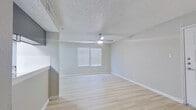 This single-floor residence offers a clean, modern aesthetic throughout, with light-toned wood-style flooring that flows seamlessly from room to room, creating a cohesive and inviting atmosphere. Neutral gray walls and crisp white trim provide a versatile backdrop throughout the space.

The living area is bright and open, featuring a ceiling fan with integrated lighting, a textured ceiling, and a window dressed with horizontal blinds that allows natural light to fill the room. Adjacent to the living space, the galley-style kitchen is efficiently laid out with gray cabinetry, white countertops, a subway tile backsplash, and stainless steel appliances including a refrigerator, electric range, and over-range microwave. A pass-through opening connects the kitchen to the main living area.

The bedrooms are generously proportioned, each featuring the same light wood-style flooring, neutral walls, and windows with blinds that bring in natural light. Closet storage is provided in the bedrooms, including a double-door closet option in one room.

Two full bathrooms serve the space, each finished with gray vanity cabinetry, white quartz-style countertops, undermount sinks with modern chrome fixtures, large-format tile surrounding the tub/shower combinations, and wood-style flooring — delivering a clean and updated look throughout.