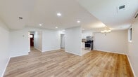 This single-floor, 2-bedroom, 1-bathroom home offers a thoughtfully designed layout that maximizes functionality and comfort. The open-concept living and kitchen area forms the heart of the home, featuring light hardwood-style flooring that flows seamlessly throughout the main space. Recessed lighting illuminates the generous living room, which is brightened further by a large sliding glass door and an additional window that offer outdoor views and bring in ample natural light.

The kitchen is efficiently designed with white cabinetry, granite-style countertops, tile flooring, and a full suite of stainless steel appliances, including a gas range, dishwasher, and refrigerator. A range hood and under-cabinet storage add to its practicality.

A hallway connects the main living area to the private quarters, where two bedrooms are finished with plush wall-to-wall carpeting and windows that invite natural light. The spacious primary bedroom includes a built-in closet and direct access to the full bathroom. The bathroom features a tiled tub-shower combination with a decorative mosaic accent border, adding a refined touch.

Additional storage is available via a dedicated closet. The home's clean, neutral palette and cohesive design create a bright, move-in-ready living environment.