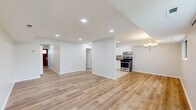 This single-floor, 2-bedroom, 1-bathroom home offers a thoughtfully designed layout that maximizes functionality and comfort. The open-concept living and kitchen area forms the heart of the home, featuring light hardwood-style flooring that flows seamlessly throughout the main space. Recessed lighting illuminates the generous living room, which is brightened further by a large sliding glass door and an additional window that offer outdoor views and bring in ample natural light.

The kitchen is efficiently designed with white cabinetry, granite-style countertops, tile flooring, and a full suite of stainless steel appliances, including a gas range, dishwasher, and refrigerator. A range hood and under-cabinet storage add to its practicality.

A hallway connects the main living area to the private quarters, where two bedrooms are finished with plush wall-to-wall carpeting and windows that invite natural light. The spacious primary bedroom includes a built-in closet and direct access to the full bathroom. The bathroom features a tiled tub-shower combination with a decorative mosaic accent border, adding a refined touch.

Additional storage is available via a dedicated closet. The home's clean, neutral palette and cohesive design create a bright, move-in-ready living environment.