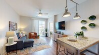 Located at 10945 Nuckols Road in Glen Allen, Virginia, this well-appointed one-bedroom, one-bathroom residence offers a thoughtfully designed single-floor layout that maximizes every square foot. The open-concept living and kitchen area forms the heart of the home, where wood-style flooring, a ceiling fan, and neutral tones create a bright, welcoming atmosphere. A sliding glass door floods the living room with natural light and opens onto a private balcony with outdoor views.

The kitchen is both functional and stylish, featuring white shaker cabinetry, granite countertops, a subway tile backsplash, and a full suite of stainless steel appliances including a refrigerator, range, microwave, and dishwasher. Pendant lighting over a granite-topped dining table adds a modern touch.

The bedroom is a calm retreat with plush carpeting, a ceiling fan, and a generously sized window that invites natural light. The bathroom is elegantly finished with large-format marble-style tile in a glass-enclosed walk-in shower and hardwood-style flooring. A dedicated laundry area with a stacked washer and dryer adds everyday convenience, completing this efficient and modern residence.