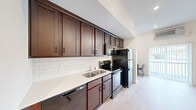 Located at 1310 E St Louis Street in Springfield, MO, this one-bedroom, one-bathroom unit offers an efficient and thoughtfully designed layout across a single floor. Light wood-style flooring runs throughout, lending a clean, contemporary feel to every room.

The kitchen is a standout feature, equipped with rich dark-wood cabinetry extending to the ceiling for ample storage, white subway tile backsplash, light quartz countertops, a double-basin stainless steel sink, and a full suite of appliances including a refrigerator, electric range, microwave, and dishwasher.

A well-proportioned hallway connects the main spaces, with recessed lighting and crisp white walls creating a bright, open atmosphere. The living area benefits from a sliding door with vertical blinds that invites natural light and accommodates both a seating and dining arrangement. A wall-mounted HVAC unit and ceiling fan provide climate control.

The spacious bedroom features tall ceilings, recessed lighting, and a ceiling fan, providing a comfortable and airy retreat. A dedicated closet offers practical storage. The bathroom includes a wide vanity with dark cabinetry, quartz countertop, a large wall mirror, and brushed nickel fixtures, maintaining the consistent modern aesthetic found throughout the unit.