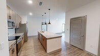 Located at 80 West Oxmoor Road in Birmingham, AL, this modern single-floor home offers 2 bedrooms, 3 bathrooms, and a thoughtfully designed open-concept layout. Light wood-look flooring flows throughout, complementing the clean, neutral palette of the interior.

The combined kitchen and living area serves as the heart of the home, anchored by a large center island with granite countertops and a built-in sink, illuminated by a trio of sleek pendant lights. The kitchen features warm-toned cabinetry, a white tile backsplash, and a full suite of stainless steel appliances. The living area extends naturally from the kitchen, bathed in natural light from large windows with outdoor views.

The primary bedroom is generously sized, with multiple windows offering outdoor views and access to ample closet space. In total, five closets provide exceptional storage throughout the home, including a dedicated pantry and laundry room. The bathrooms are well-appointed, featuring granite double vanities, modern panel-style doors, and a tub-shower combo with white tile surround and brushed nickel fixtures. The overall ambiance is clean, contemporary, and move-in ready, making this an efficient and well-appointed home.
