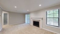 Located at 100 Calibre Brooke Way in Smyrna, GA, this one-bedroom, one-bathroom residence offers a well-designed single-floor layout that maximizes every inch of its living space. The open-concept living room is a standout, featuring a tile-surround fireplace with a classic white mantel, recessed lighting, crown molding, soft neutral carpeting, and multiple windows that invite natural light and views of surrounding greenery. A sliding glass door further connects the living area to the outdoors.

The kitchen is appointed with rich dark cabinetry, granite countertops, a gray subway tile backsplash, wood-look flooring, and a full suite of stainless steel appliances including a gas range, microwave, and refrigerator. A louvered door leads conveniently to a dedicated utility room.

The bedroom is a comfortable retreat with plush carpeting, a ceiling fan, natural light from a large window, and direct access to a closet. The bathroom offers a clean, classic aesthetic with a tiled soaking tub and shower combination. Neutral tones and consistent finishes throughout the space create a cohesive and welcoming ambiance.