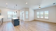 Located in Lewisville, TX, this well-designed 2-bedroom, 2-bathroom single-story residence offers a clean, modern aesthetic with thoughtful details throughout. The open-concept kitchen and living area serves as the heart of the home, featuring light wood-grain cabinetry, stainless steel appliances including a French door refrigerator, a center island with pendant lighting, recessed ceiling lights, and large windows that invite abundant natural light. Light wood-style luxury vinyl plank flooring runs consistently throughout the space, enhancing its bright and cohesive feel.

Both bedrooms are generously proportioned, with the primary bedroom offering ceiling fan, large windows with outdoor views, and direct access to its en-suite bathroom. The bathrooms are finished with warm wood vanity cabinetry, white quartz countertops, black-framed mirrors, and matching luxury vinyl plank flooring. Each bedroom is served by a dedicated walk-in closet equipped with shelving and hanging rods. A private outdoor patio with a manicured lawn area and iron railing enclosure provides a comfortable exterior retreat. The hallway connects all rooms in an efficient layout, completing this well-appointed single-floor residence.