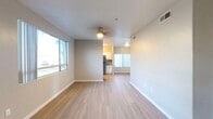 Located in Goodyear, Arizona, this single-story, 3-bedroom, 2-bathroom home features a clean, modern design with light-toned wood-style flooring carried consistently throughout the space. The open-concept living and dining area is bright and welcoming, with large windows that invite natural light and provide views of the surrounding neighborhood. A ceiling fan adds comfort to the main living space, which flows seamlessly into the kitchen.

The kitchen is well-appointed with white shaker-style cabinetry, a classic subway tile backsplash, stainless steel appliances including a refrigerator, dishwasher, and range, and a window above the sink for added natural light. The layout maximizes functionality with ample counter and storage space.

Each of the three bedrooms features the same wood-style flooring, neutral-toned walls, and windows fitted with blinds for privacy and light control. The primary bedroom includes a ceiling fan and access to a closet. The primary bathroom offers a floating dark wood vanity with a white basin sink, a framed mirror, and a separate water closet with a shower. A second full bathroom serves the remaining bedrooms. The entry foyer is open and airy, framed by large windows that fill the space with natural Arizona sunlight.
