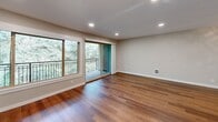 Located at 433 Bellevue Way SE in the heart of Bellevue, Washington, this well-appointed 2-bedroom, 1-bathroom residence offers a thoughtfully designed single-level layout. Rich hardwood flooring runs throughout every room, lending warmth and visual continuity across the entire space.

The open living area is bright and welcoming, featuring recessed lighting, a sliding glass door, and a large picture window that frame lush, wooded views and lead out to a private balcony with a sleek metal railing. The kitchen has been tastefully updated with crisp white shaker cabinetry, quartz countertops, a mosaic tile backsplash, and stainless steel appliances, including a refrigerator and dishwasher, along with a peninsula that provides added prep and serving space.

Both bedrooms are comfortably sized and equipped with ceiling fans. The primary bedroom features a double-door closet and hardwood floors, while the second bedroom benefits from natural light through a dedicated window. The bathroom continues the refined aesthetic with white cabinetry, a quartz vanity countertop, and brushed nickel fixtures. A connecting hallway links all rooms efficiently, completing this clean, move-in-ready layout in one of Bellevue's most sought-after addresses.