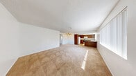 Located at 5001 W El Parque Ave in Las Vegas, NV, this single-floor 2-bedroom, 2-bathroom unit offers a practical and comfortable layout. The open-plan living room and kitchen area forms the heart of the home, featuring neutral carpet, a textured ceiling, and a ceiling fan that enhances airflow throughout the space. Large windows with vertical blinds allow natural light to fill the living area, creating a bright and airy atmosphere.

The kitchen is well-equipped with warm-toned wood cabinetry, granite-style countertops, a double-basin sink, a dishwasher, and a range — all complemented by hardwood-style flooring that transitions seamlessly from the kitchen into the hallway.

Both bedrooms are carpeted and finished with clean white walls and textured ceilings. The primary bedroom offers a generous footprint with a window providing natural light, while the second bedroom includes a closet and direct sightlines to the kitchen area. Each bedroom provides a calm, neutral environment.

The two bathrooms are consistent in design, each featuring warm wood vanities with granite-style countertops, white subway-tiled tub-shower combinations, hardwood-style flooring, and ample mirror space — offering clean, functional finishes throughout.