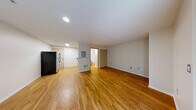 Located at 219 E Garfield St in Seattle's Capitol Hill neighborhood, this efficiently designed single-floor unit makes smart use of its compact footprint. Warm hardwood-style flooring runs consistently throughout, lending a cohesive and inviting feel to every room.

The kitchen is outfitted with stainless steel appliances, including a gas range, dishwasher, and full-size refrigerator, complemented by light wood cabinetry, a granite-style countertop, and a stainless steel sink. Bright overhead fluorescent lighting ensures a well-lit cooking space.

A central hallway connects the main living areas, lined with flush circular ceiling lights that maintain a clean, modern aesthetic. The bathroom features a full bathtub and toilet, with a vanity topped in a rich dark granite-style surface, warm wood cabinetry, and a large mirror above the sink.

A dedicated utility closet in the hallway houses a stacked washer and dryer alongside a water heater, providing the convenience of in-unit laundry. The main living area is bright and open, with a large window offering views of the surrounding greenery and filling the space with natural light. Sliding closet doors provide ample storage, completing this practical and efficiently arranged unit.