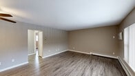 Located at 3838 West Sylvania Avenue in Toledo, Ohio, this two-bedroom, two-bathroom residence offers a practical and well-appointed single-floor layout finished with consistent wood-look flooring throughout. The spacious living room serves as the heart of the home, featuring neutral taupe walls, a ceiling fan, baseboard heating, and a clean, open feel that flows naturally into the rest of the unit. A dedicated entryway with a closet provides convenient storage upon arrival. The galley-style kitchen is thoughtfully updated with white shaker cabinetry, granite-look countertops, a stainless steel sink, and stainless steel appliances, including a full-size refrigerator. The primary bedroom is generously sized and includes dual closets with white bi-fold doors and a flush-mount ceiling light. The second bedroom features a ceiling fan, a large window with exterior views, and baseboard heating. Both bathrooms are well-maintained; one includes a tiled walk-in shower with mosaic floor detailing and a vanity, while the other offers a bright window with neighborhood views. A connecting hallway ties all rooms together efficiently. The overall aesthetic is clean and neutral, presenting a move-in-ready living environment.