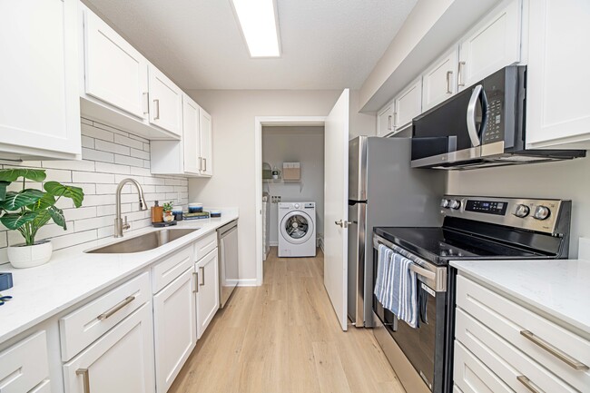 Kitchen with granite counters, modern cabinetry, and stainless steel appliances - The Collins Apartment Homes