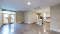 Located at 1825 San Jacinto St in the heart of Houston, TX, this modern 2-bedroom, 2-bathroom residence offers a sleek, open-concept single-level layout with a clean, contemporary aesthetic throughout. Polished concrete floors flow seamlessly across the entire space, lending an industrial-chic character that ties every room together.

The open living and dining area is bathed in natural light from large double French doors, creating a bright and welcoming atmosphere. The kitchen is a standout feature, boasting crisp white cabinetry that reaches the ceiling, a striking quartz-topped island with an undermount sink, pendant lighting, a textured tile backsplash, and a full suite of stainless steel appliances including a gas range, microwave, and refrigerator with ice and water dispenser.

Both bedrooms are generously proportioned, each with a ceiling fan, polished concrete floors, and windows that invite natural light. Each bedroom is served by its own dedicated closet with built-in shelving and hanging rods. The two bathrooms are finished in a clean, minimalist style with polished concrete floors, white fixtures, and tub-shower combinations. The hallways connect all areas efficiently, with louvered-door storage closets providing additional organization. This residence combines urban style with practical functionality in a prime downtown Houston location.