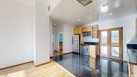 Located at 220 W 5th St in the heart of Downtown Los Angeles, this 1-bedroom, 2-bathroom residence offers a thoughtfully designed layout across a single floor. The living room is bathed in natural light through large, multi-pane windows that frame sweeping city views, complemented by warm hardwood flooring throughout. Tall ceilings enhance the open, airy feel of the living spaces.

The kitchen features a polished dark granite countertop, light maple cabinetry with glass-front upper cabinets, stainless steel appliances including a refrigerator, range, microwave, and dishwasher, and striking dark tile flooring that distinguishes it from the rest of the unit.

The spacious primary bedroom offers generous proportions, hardwood floors, elevated ceilings, and oversized windows with city views. Elegant wood-framed sliding glass doors add a refined architectural detail, connecting the bedroom to adjacent spaces.

Both bathrooms are finished with cream marble tile, featuring tub/shower combinations with glass enclosures, light maple vanities, and dark granite countertops, providing a clean and cohesive aesthetic. A hallway connects the rooms efficiently, completing this well-organized urban residence in one of LA's most vibrant neighborhoods.