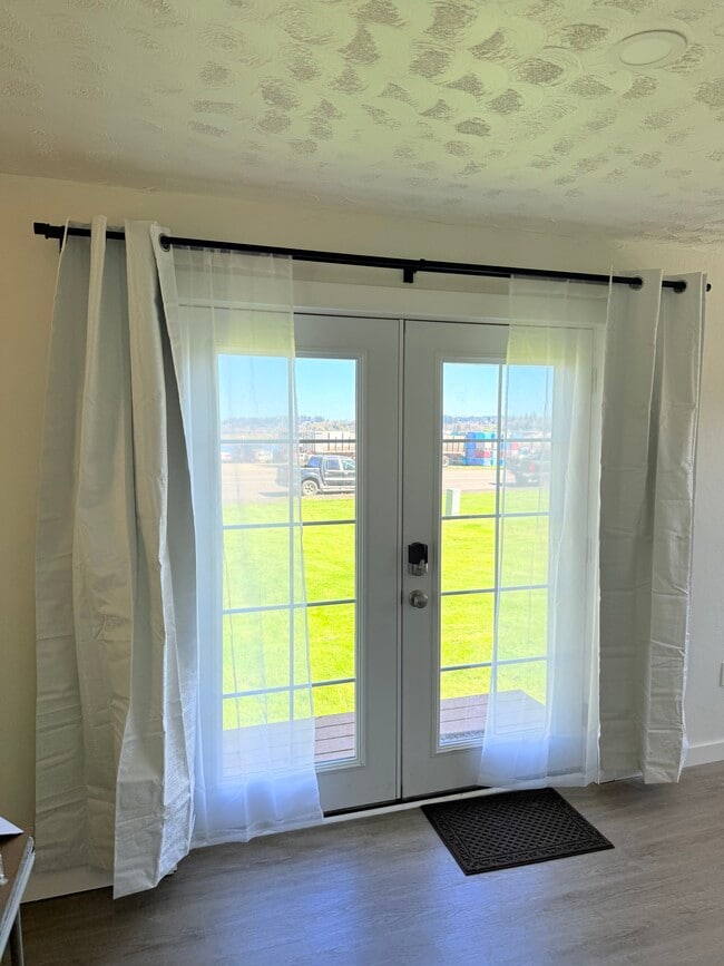 Entrada con puerta francesa, césped y río al otro lado del camino. - 103 A St