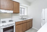 Located at 1703 Cresthill Ave in Royal Oak, Michigan, this single-floor home offers a clean, functional layout designed for comfortable everyday living. The kitchen is a standout feature, outfitted with warm oak cabinetry spanning both upper and lower sections, generous white countertop workspace, light vinyl flooring, and essential appliances including a range and refrigerator. Under-cabinet lighting adds a practical touch, while a sink with a window view enhances the bright, airy feel of the space. The bedrooms are carpeted in neutral tones and bathed in natural light courtesy of large windows dressed with vertical and horizontal blinds. Each bedroom includes closet storage, with one featuring a set of louvered bifold doors. The bathroom is efficiently arranged with an oak vanity, a white countertop with an integrated sink, tile flooring, and a glass-enclosed shower-tub combination. The overall aesthetic throughout the home is light and neutral, with white walls, clean trim, and consistent finishes that create a cohesive and move-in-ready environment. The doll-house view reveals a compact yet well-organized floor plan that maximizes the use of available space across all rooms.
